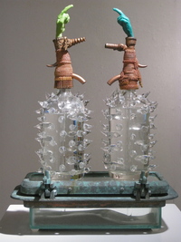 <div class='title'>Mine!</div><br>Seltzer bottles, cast, flameworked and sheet and stained glass,<br>found porthole, brass pull-chain, plumber's putty, caulk, water, sand<br><br>SOLD