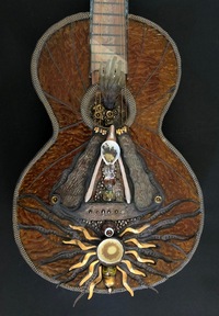 <div class='title'>Earth Wind Fire</div><br>cast (wishbone and hand) and flameworked (body, beads, flame) glass, sheet and stained glass, guitar, sea shells, sea urchins, metal findings<br>12"w x 40"h x 7"d<br>